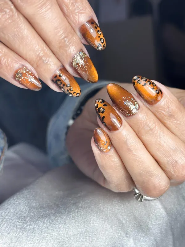 Uñas en cobre con animal print negro y laminilla dorada