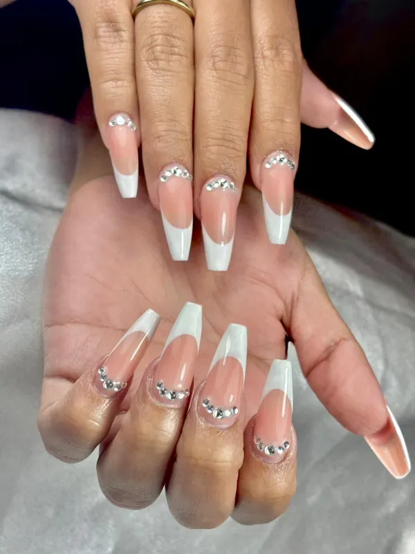 Uñas largas con francesa blanca y una línea de cristales junto a la cutícula